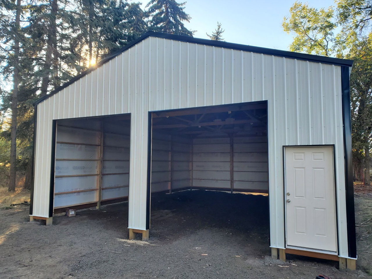 Two-bay post frame garage with tall open overhead doors built in the Spokane area